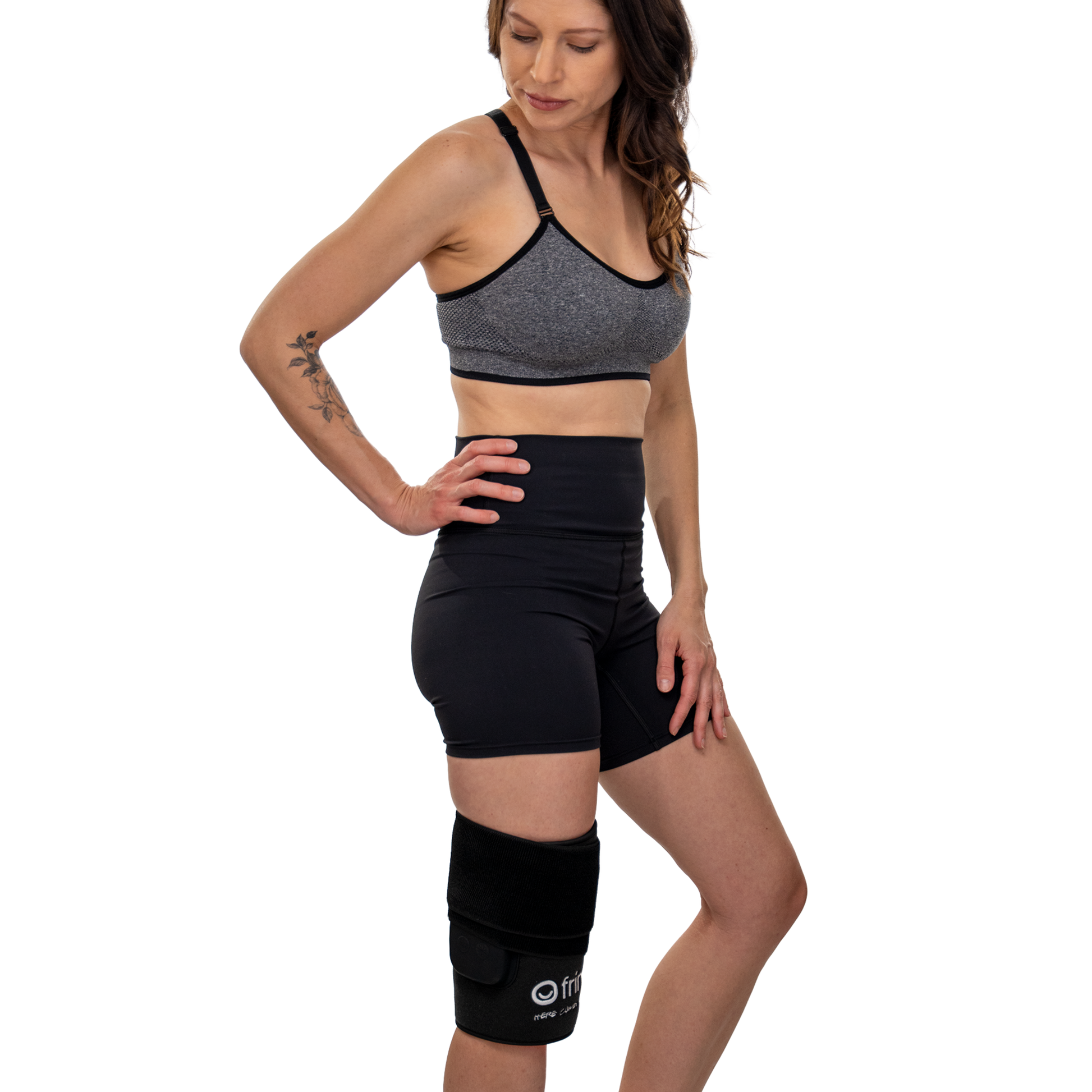 Woman wearing a gray sports bra and black shorts with a Fringe red light wrap on knee on a white background